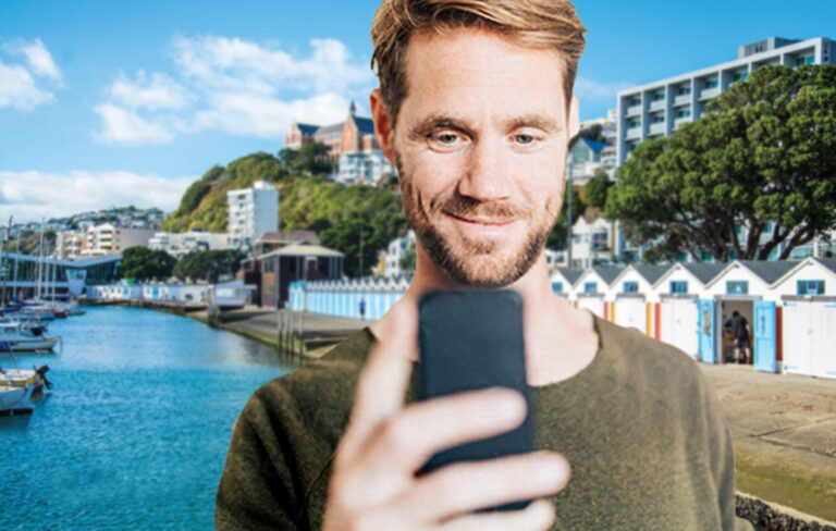 Angus Williams looks at phone at Wellington's Oriental Bay.