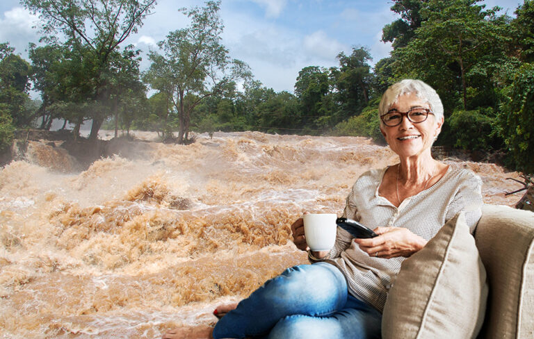 older lady on couch with tv remote with flooding image in the background