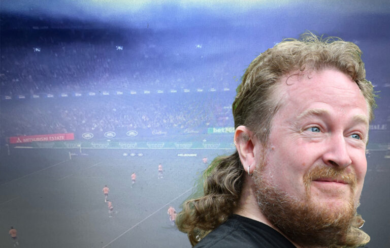 Man with mullet in front of smokey indoor stadium