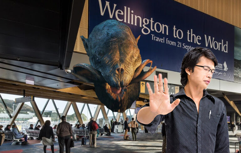 Giant snow troll model mounted in wellington airport with man waving hand dismissively