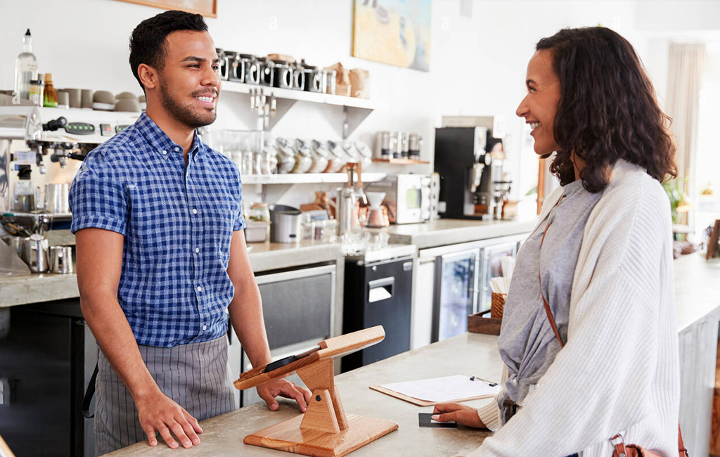 male barista interacting with female customer