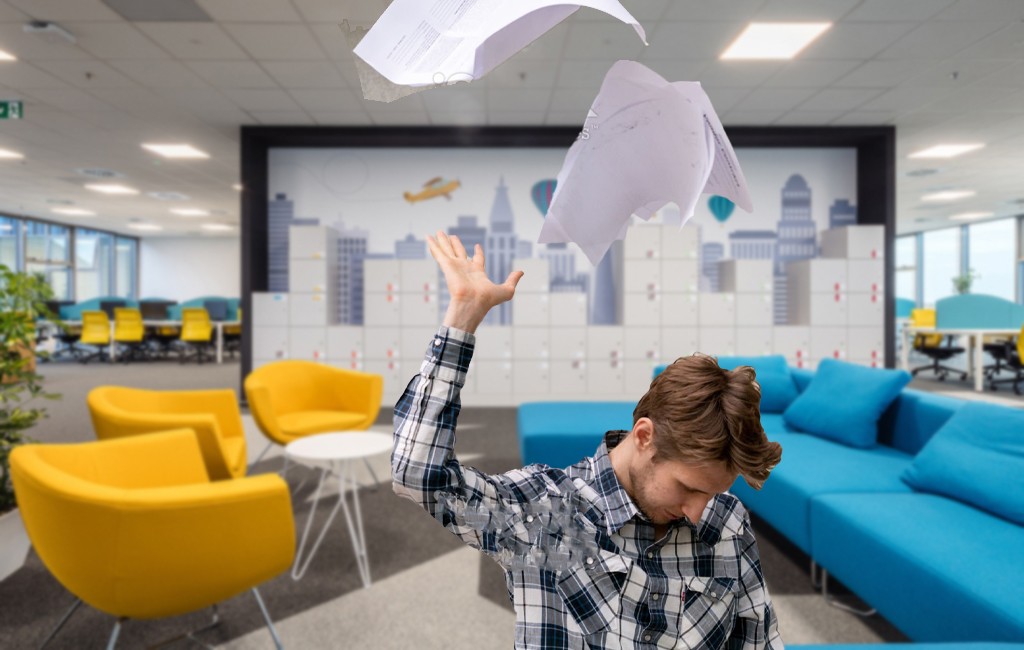 man in office tossing papers in the air in frustration