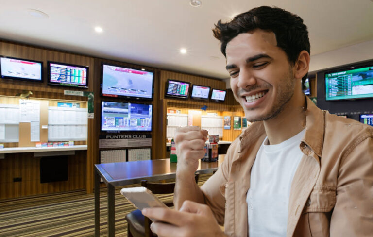 man smiling at phone while at TAB