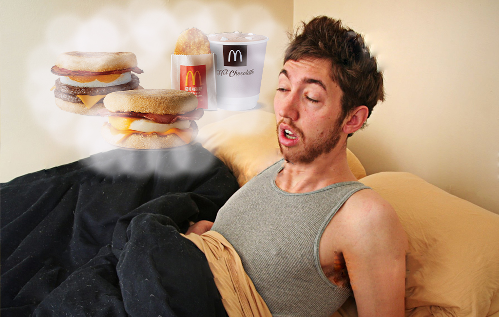 Man waking up hungover in bed, thinking about a maccas hunger buster