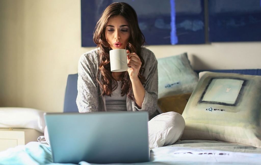 woman watching netflix on laptop in bed