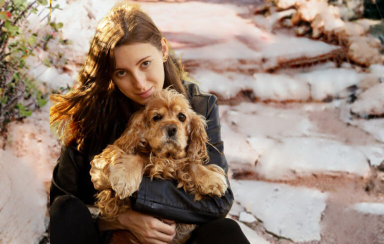 Woman cuddling sad-looking dog.