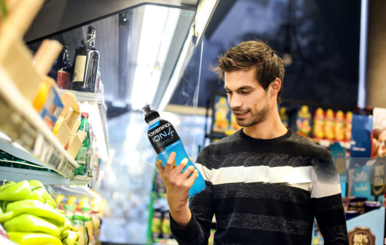 man picking up blue powerade at supermarket.