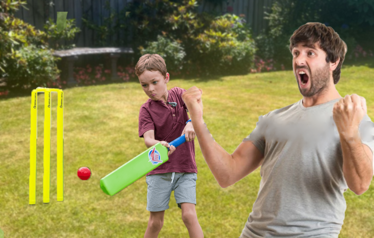 Man celebrating after bowling out his young son in backyard cricket.