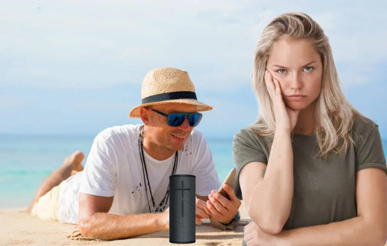 man happily looking at phone with bluetooth speaker, while woman looks annoyed.