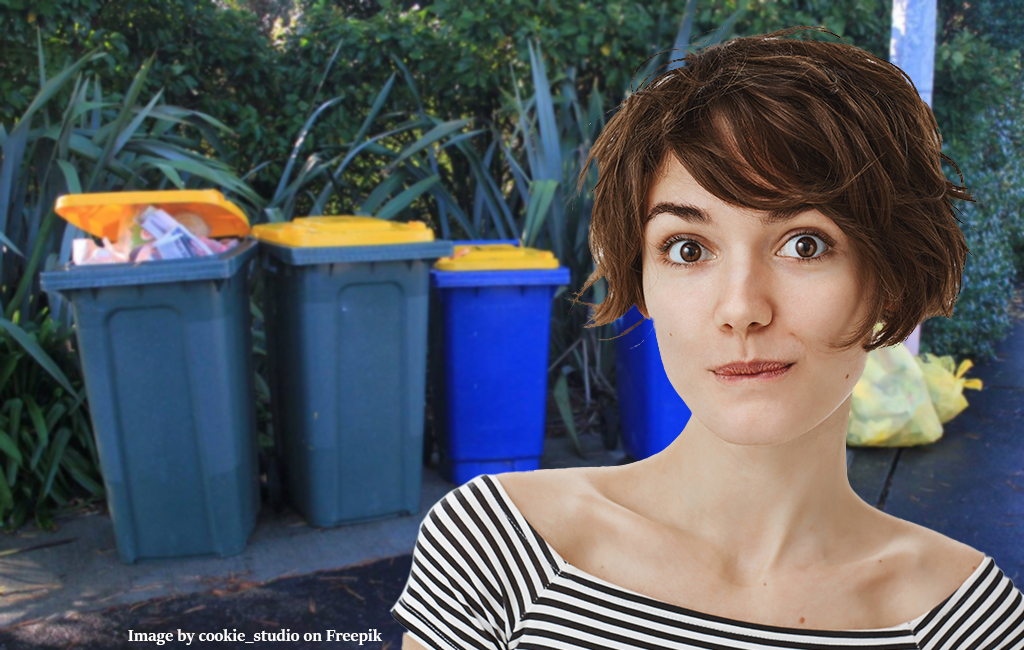 intrigued woman in front of recycling wheelie bins.