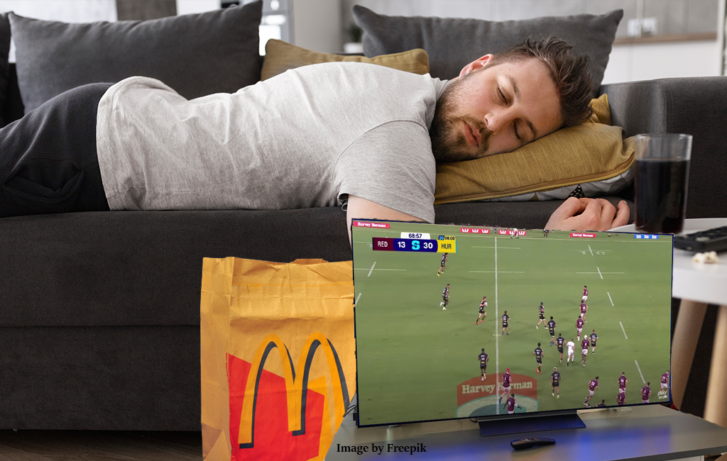man asleep on couch with maccas and sport on tv