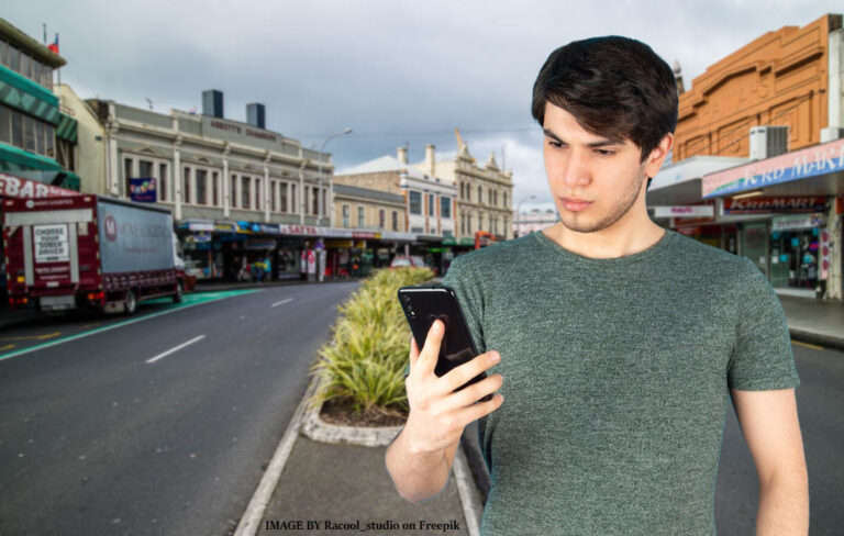 Confused man looking at phone while on K Road