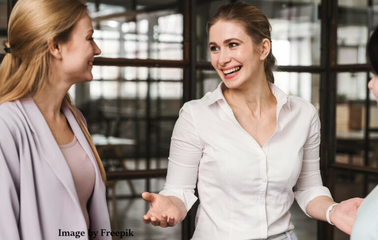 three women in office having conversation.