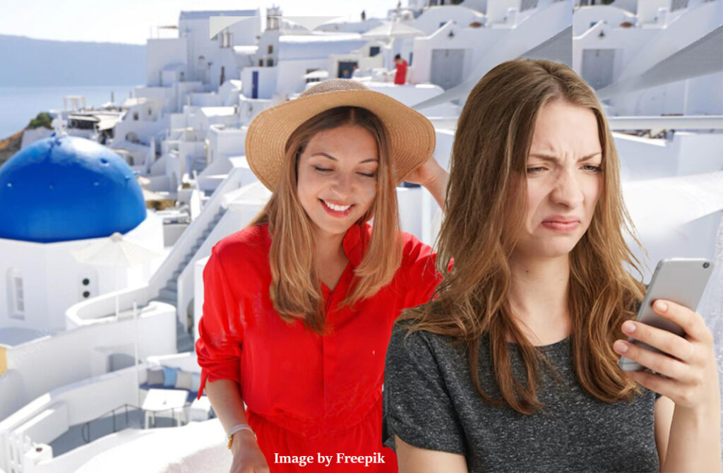 woman screwing her nose up at picture on phone, while friend is in santorini on holiday.