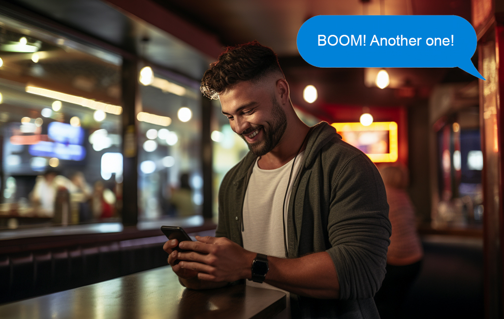 man looking at phone in bar with blue message above