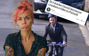 annoyed pink haired woman as david seymour rides bike.