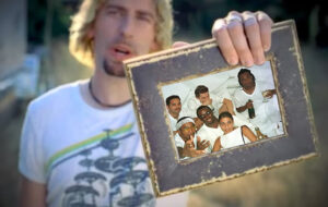 Chad Kroeger holding up photograph of Diddy party