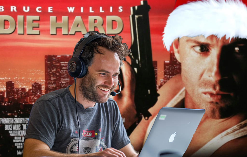 man on laptop with christmas die hard image in background