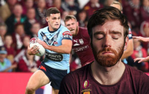 man sleeping with state of origin happening behind him.