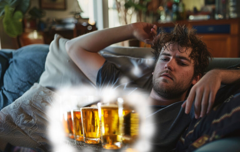 hungover man on couch thinking of the beers from last night.
