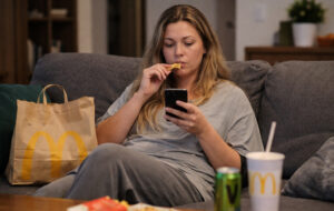 woman on couch eating mcdonalds